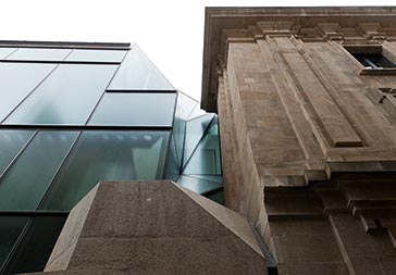  La continuidad entre el nuevo plano de fachada de vidrio y la fachada existente se resuelve mediante un repliegue del plano de vidrio, que, funcionando como canal de desagüe de la cubierta, culmina en el lucernario de la escalera principal.